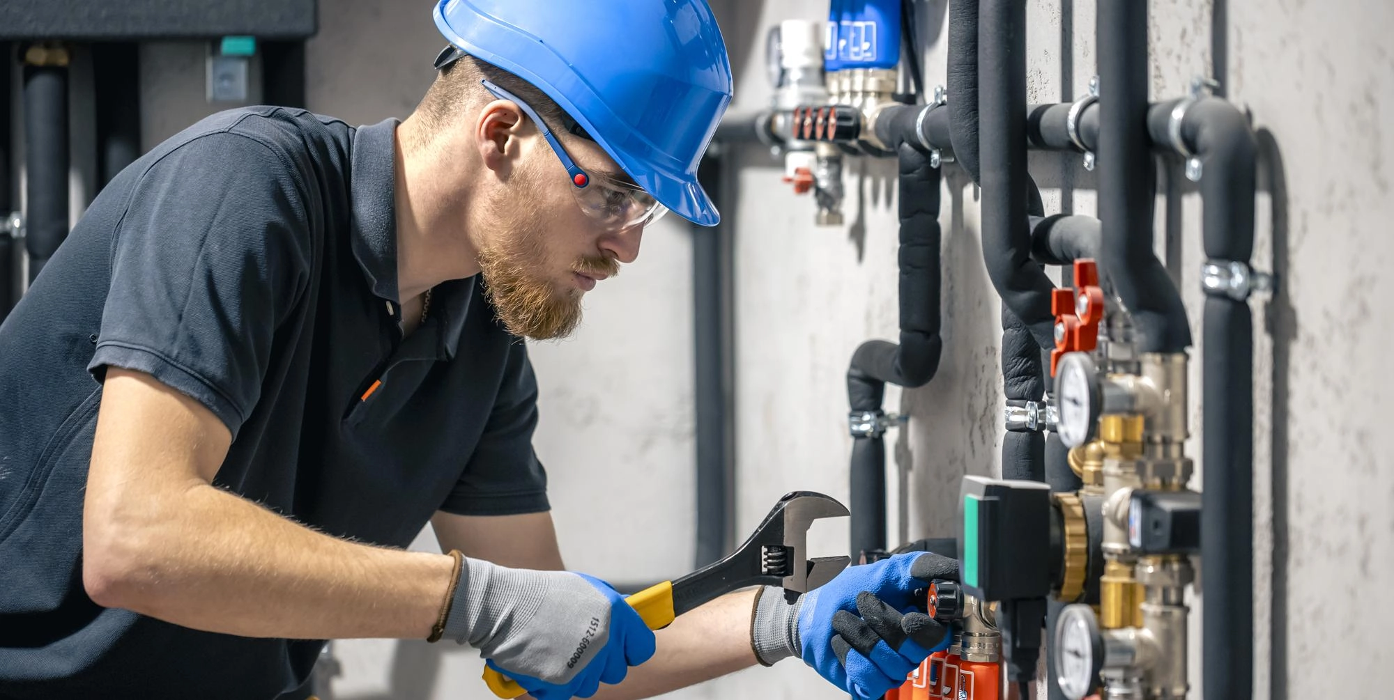 man-installs-heating-system-house-checks-pipes-with-wrench (1)